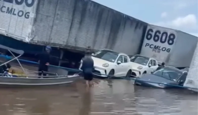 Balsa com dezenas de contêineres e veículos fica submersa na região de Parintins